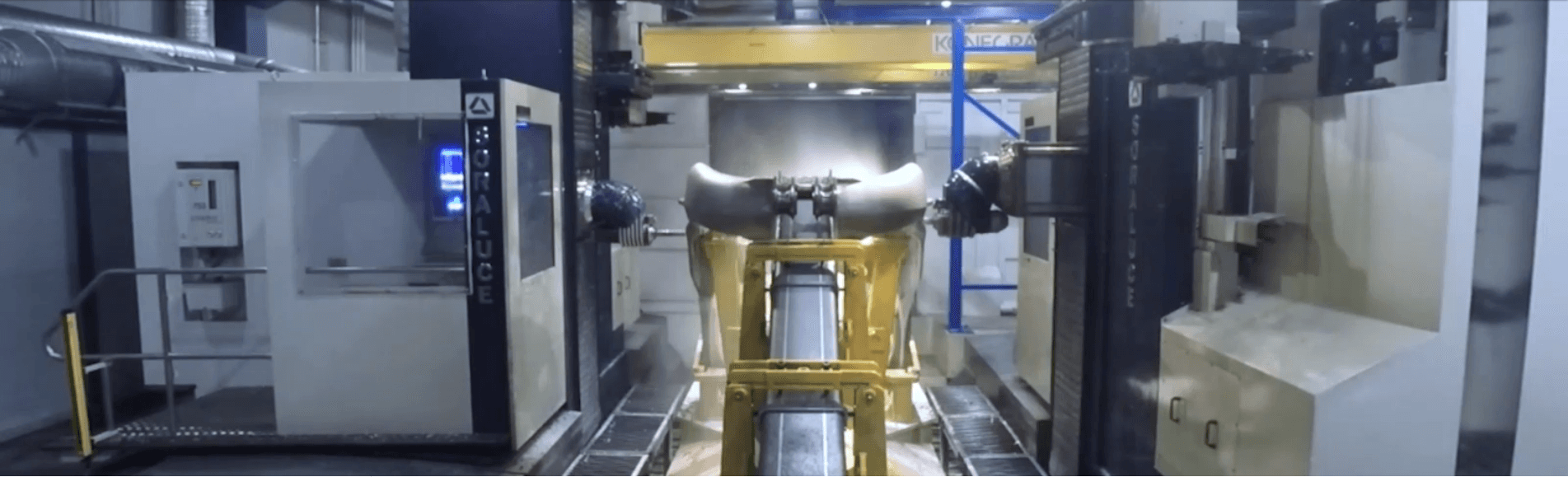 Industrial machining setup featuring a Soraluce machine working on a large metallic component in a high-tech manufacturing facility.