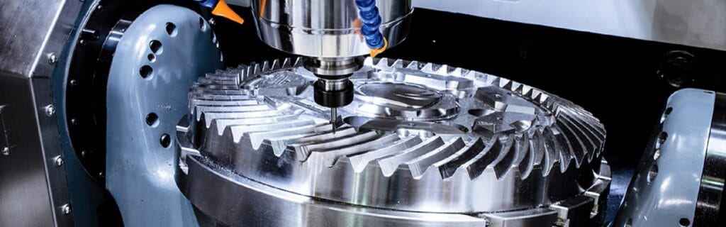 Close-up of a CNC milling machine working on a large, circular metal component with intricate teeth and grooves.